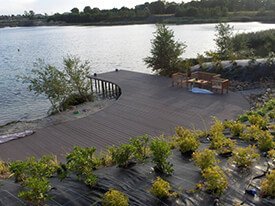 Composiet terras met tuinset aan een meer